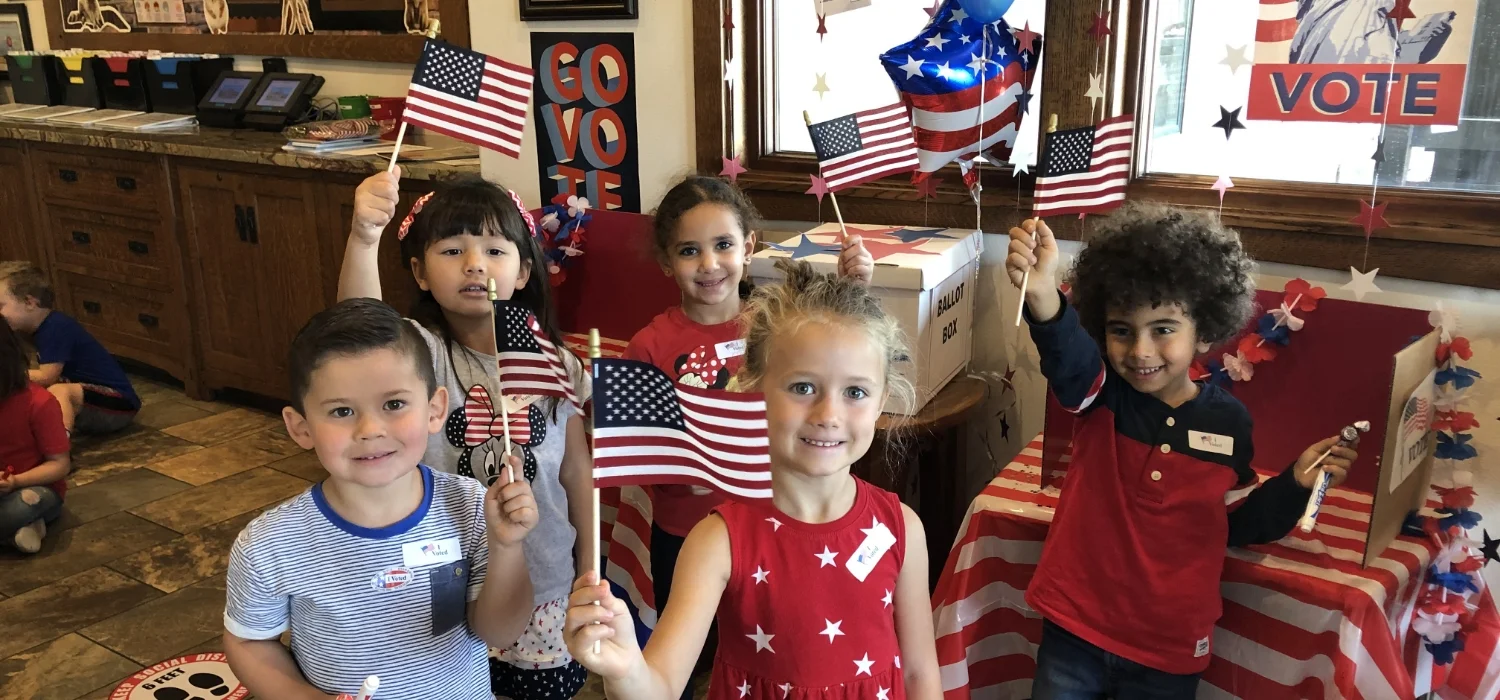 students in red, white, and blue holding American flags